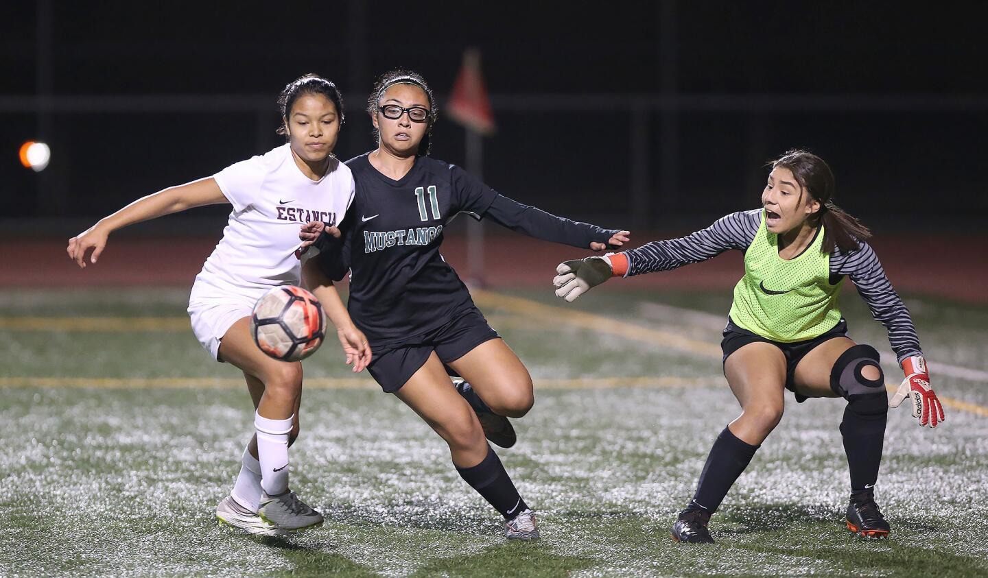 Lani Whittaker, center, tries to get a shot off for Costa Mesa High in front of Estancia goalkeeper Kimberly Martinez, right, as Daniela Garcia, left, tries to defend in an Orange Coast League match Tuesday.