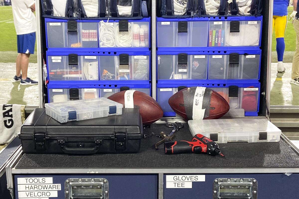 Two footballs, one from a touchdown and the other from an interception, are set aside for the players who made those plays on the Rams' sideline chest.