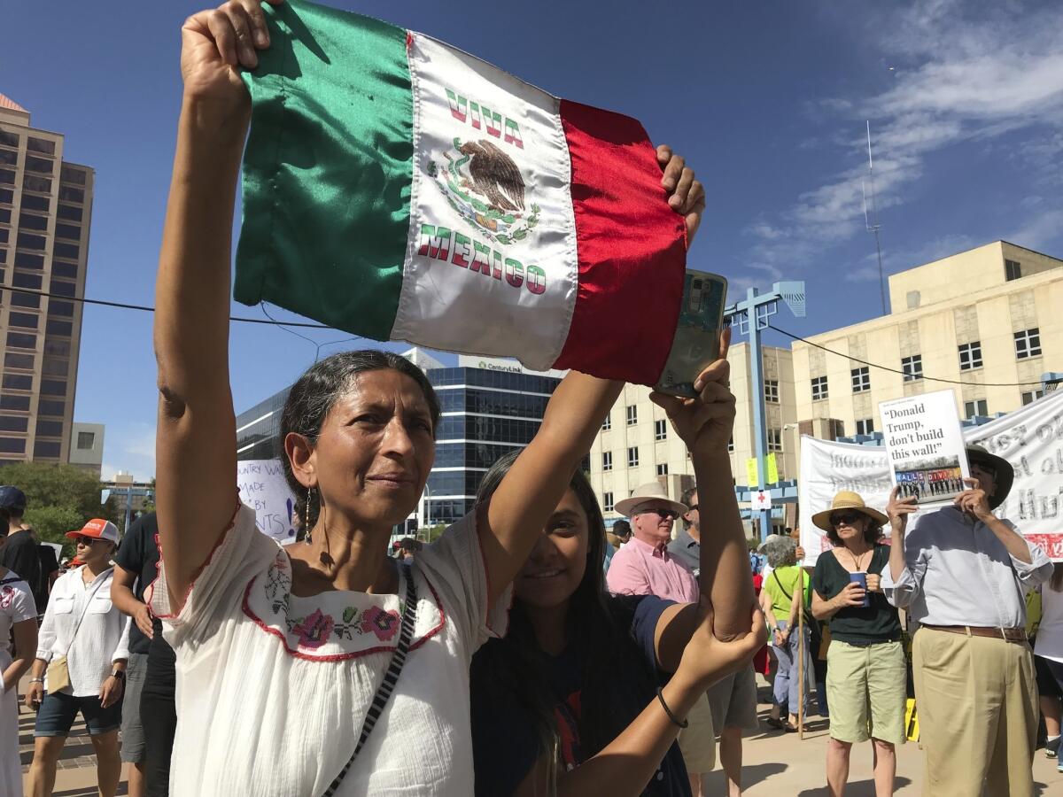 ALBUQUERQUE: Margarita Perez, with her daughter by her side, holds up a Mexican flag during a protest on Civic Plaza.