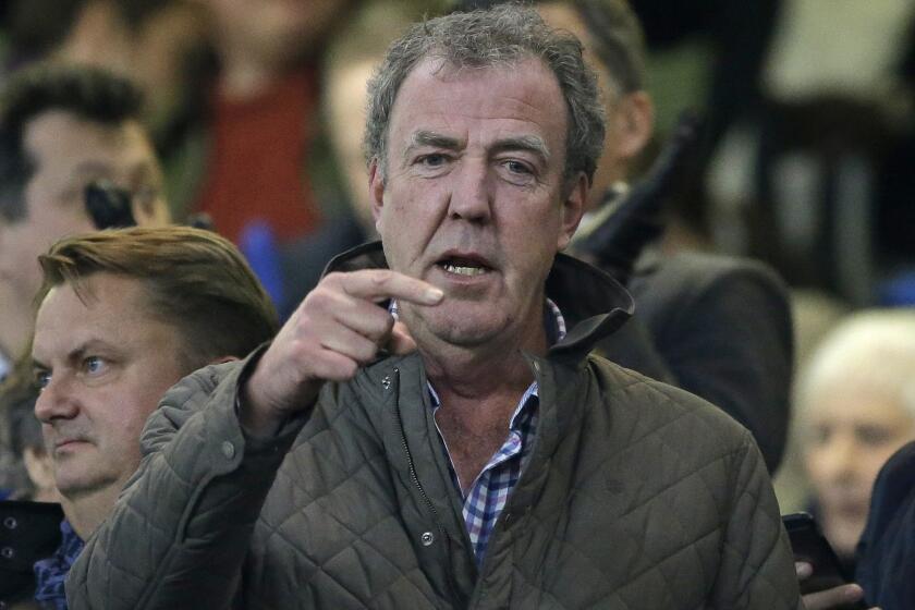 "Top Gear" host Jeremy Clarkson gestures as he takes his place in the stands before the Champions League round of 16 second leg soccer match between Chelsea and Paris Saint Germain at Stamford Bridge stadium in London, Wednesday, March 11, 2015. Clarkson has been suspended by the BBC.
