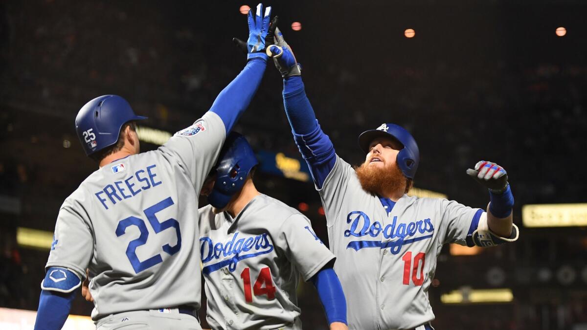 Dodgers' Justin Turner, right, celebrates his two-run home run with teammates David Freese, left, and Enrique "Kiki" Hernandez in the fifth inning at AT&T Park in San Francisco on Friday.