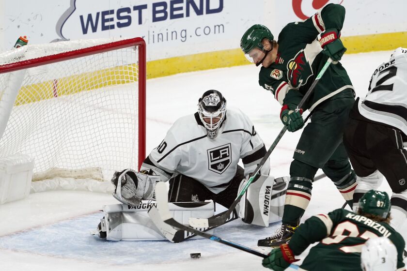 Minnesota Wild’s Nick Bjugstad, right, attempts to make a shot as Los Angeles Kings’ goalie Calvin Petersen stops the attempt in the first period of an NHL hockey game, Tuesday, Jan. 26, 2021, in St. Paul, Minn. (AP Photo/Jim Mone)