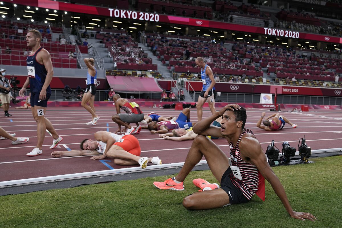 Competitors rest on the track following the decathlon 1500-meters at the 2020 Summer Olympics, Thursday, Aug. 5, 2021, in Tokyo. (AP Photo/David J. Phillip)