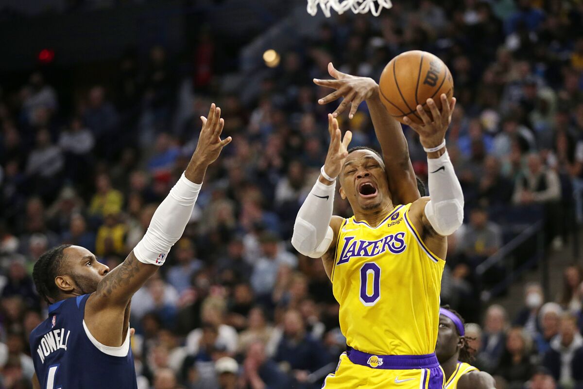 Lakers guard Russell Westbrook is fouled by Minnesota Timberwolves forward Nathan Knight as guard Jaylen Nowell helps defend.