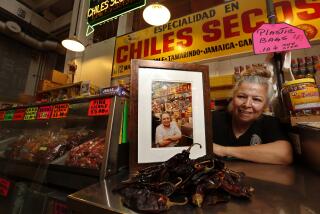 LOS ANGELES, CA-MARCH 22, 2018: Vendor Rocio Lopez, 58, is photographed next to a photograph of her father Celestine Lopez, at her stand located inside the Grand Central Market in downtown Los Angles on March 22, 2018. Celestino started the food stand back in the 1970's and Rocio took over the business after he passed away in 2008. (Mel Melcon/Los Angeles Times)