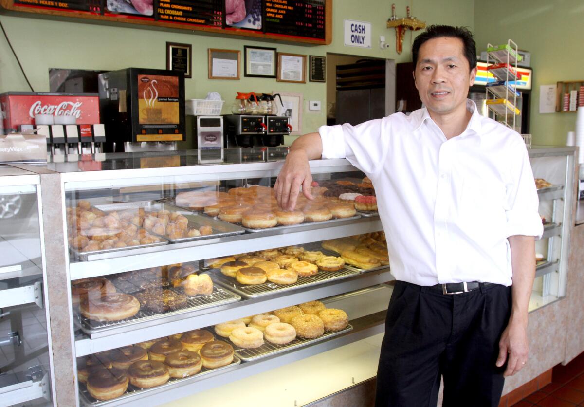 Golden Donut Place owner Ngy Si mans his shop on Foothill Boulevard, which survives there despite rising rents and nearby competition.