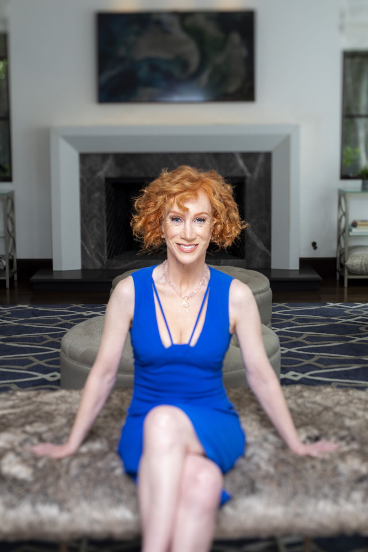 Kathy Griffin seated in her home wearing a blue dress
