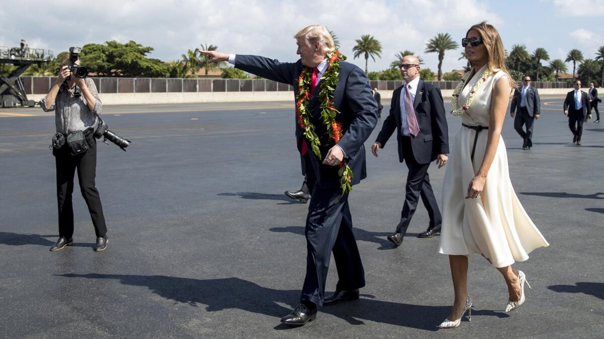 President Trump and First Lady Melania Trump wear leis as they arrive at Joint Base Pearl Harbor Hickam on Friday.
