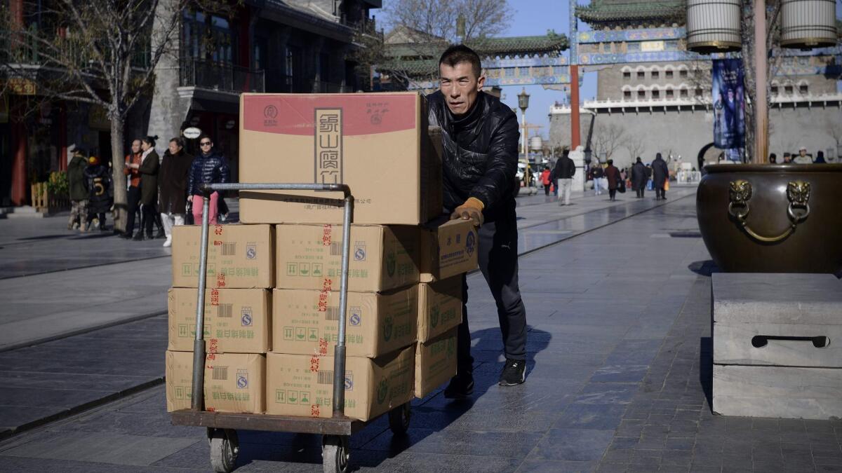A man pushes a trolley with goods along a street in Beijing in January 2017. China's producer prices rose at their swiftest pace in more than five years in December, according to the government.