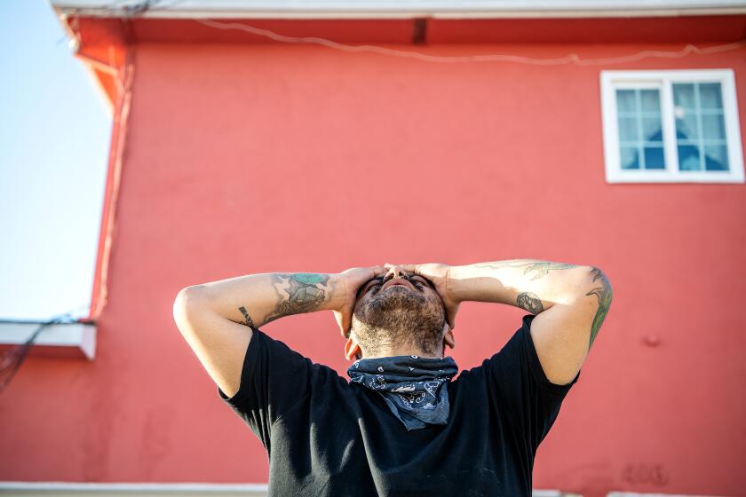 INGLEWOOD, CA - MAY 13: Restaurant worker and line cook Tony Ruiz shows his venerability and frustration while discussing his lost job during a portrait shoot in an alley on Wednesday, May 13, 2020 in Inglewood, CA. Ruiz was brought to the United States as a baby and like many, remains undocumented. When the Coronavirus pandemic hit, Ruiz was laid-off from his restaurant job and now struggles with being homeless as well since being evicted from his residence. He now finds himself having to rely on those he knows for a place to sleep from night to night. (Mariah Tauger / Los Angeles Times)