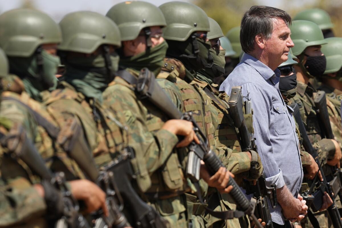 A man stands amid a group of military soldiers.