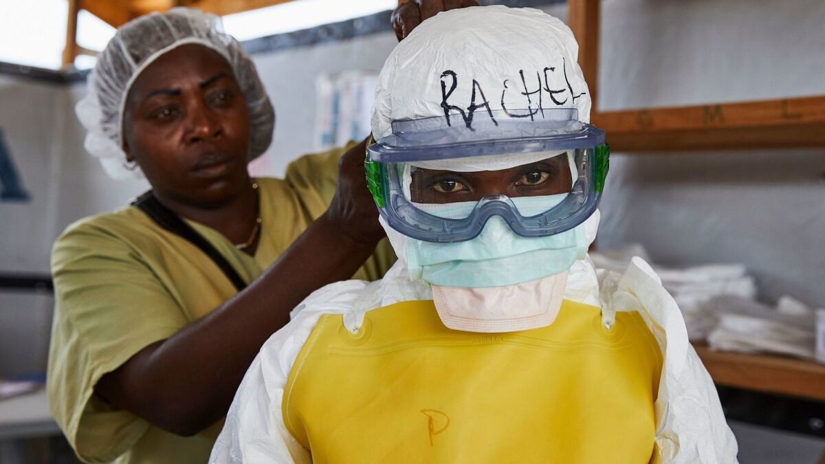 A health worker gets dressed in protective garments last month at an Ebola treatment center in the Democratic Republic of the Congo.