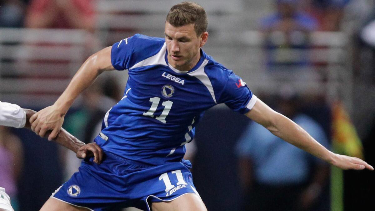 Bosnia and Herzegovina's Edin Dzeko battles for the ball during an international friendly match against Ivory Coast on May 30 in St. Louis. Dzeko's experiences as a child during the Bosnian War has made him an advocate for peace and unity in his homeland.