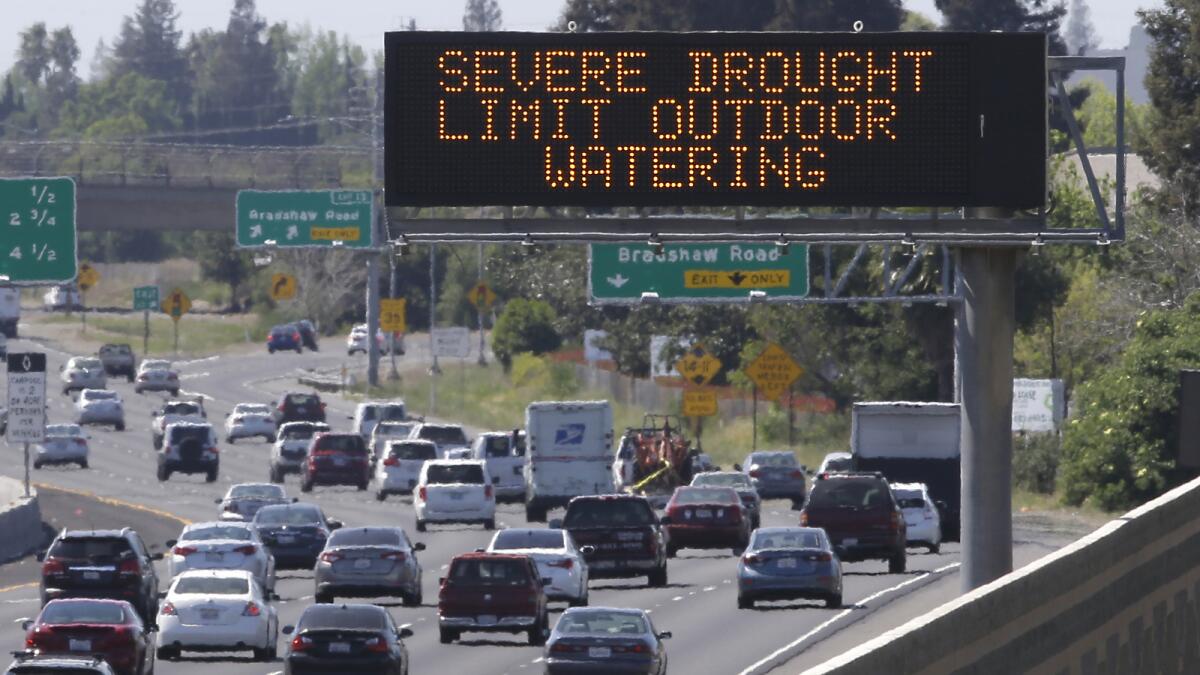 Motorists pass a sign Thursday in Rancho Cordova, Calif., reminding them to reduce water use.