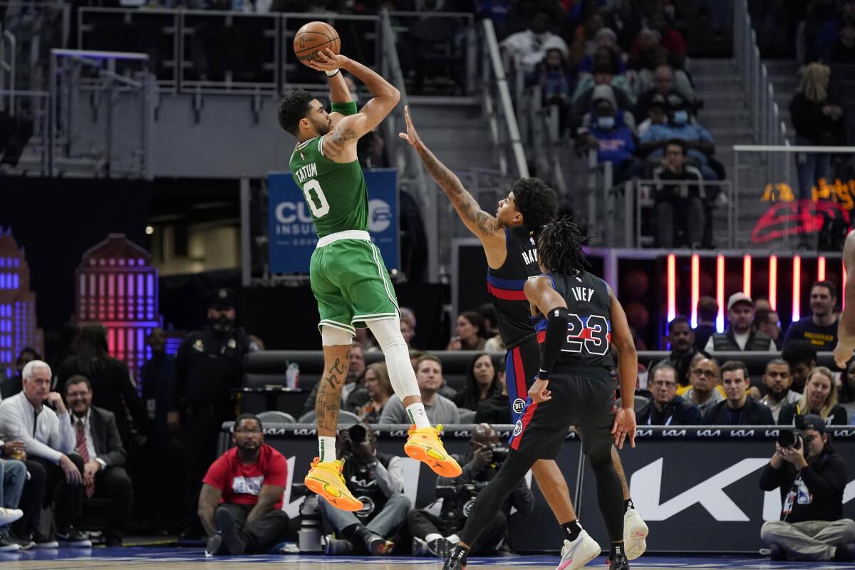 Boston Celtics forward Jayson Tatum (0) shoots over the defense of Detroit Pistons guard Killian Hayes during the second half of an NBA basketball game, Saturday, Nov. 12, 2022, in Detroit. (AP Photo/Carlos Osorio)