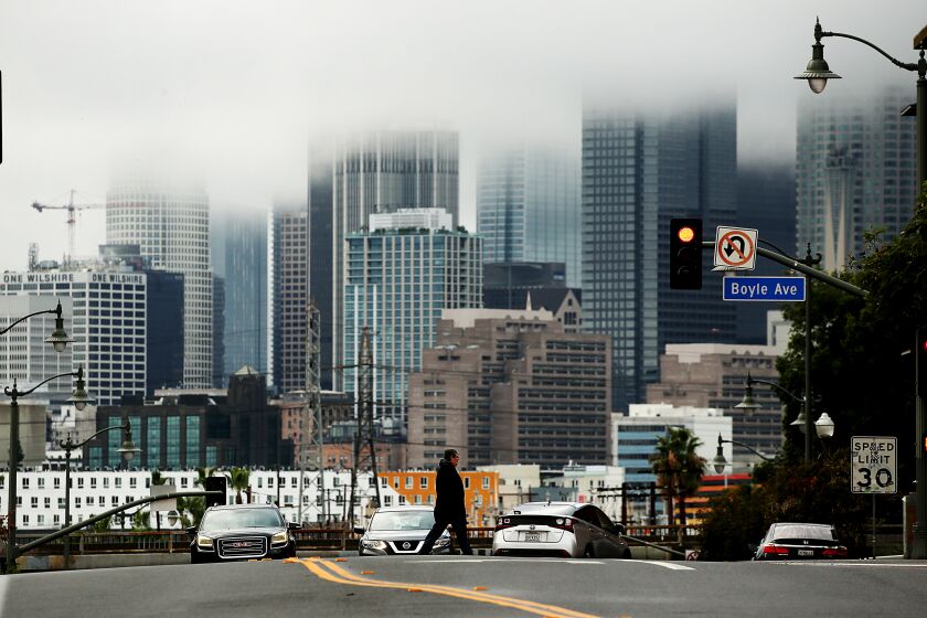 LOS ANGELES, CALIF. - JAN. 4, 2023. Rain clouds shroud the skyline of downtown Los Angeles on a rainy Wednesday afternoon, Jan. 4, 2023. Another storm is expected to bring heavier rain overnight. (Luis Sinco / Los Angeles Times)