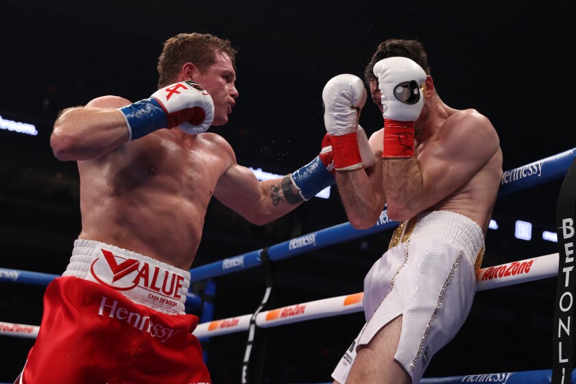 Canelo Alvarez, left, punches Callum Smith during their title fight.