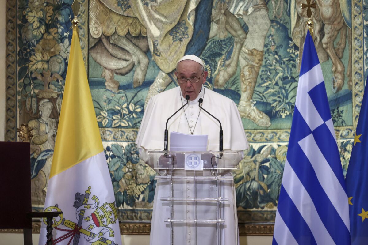 Pope Francis speaks at a lectern
