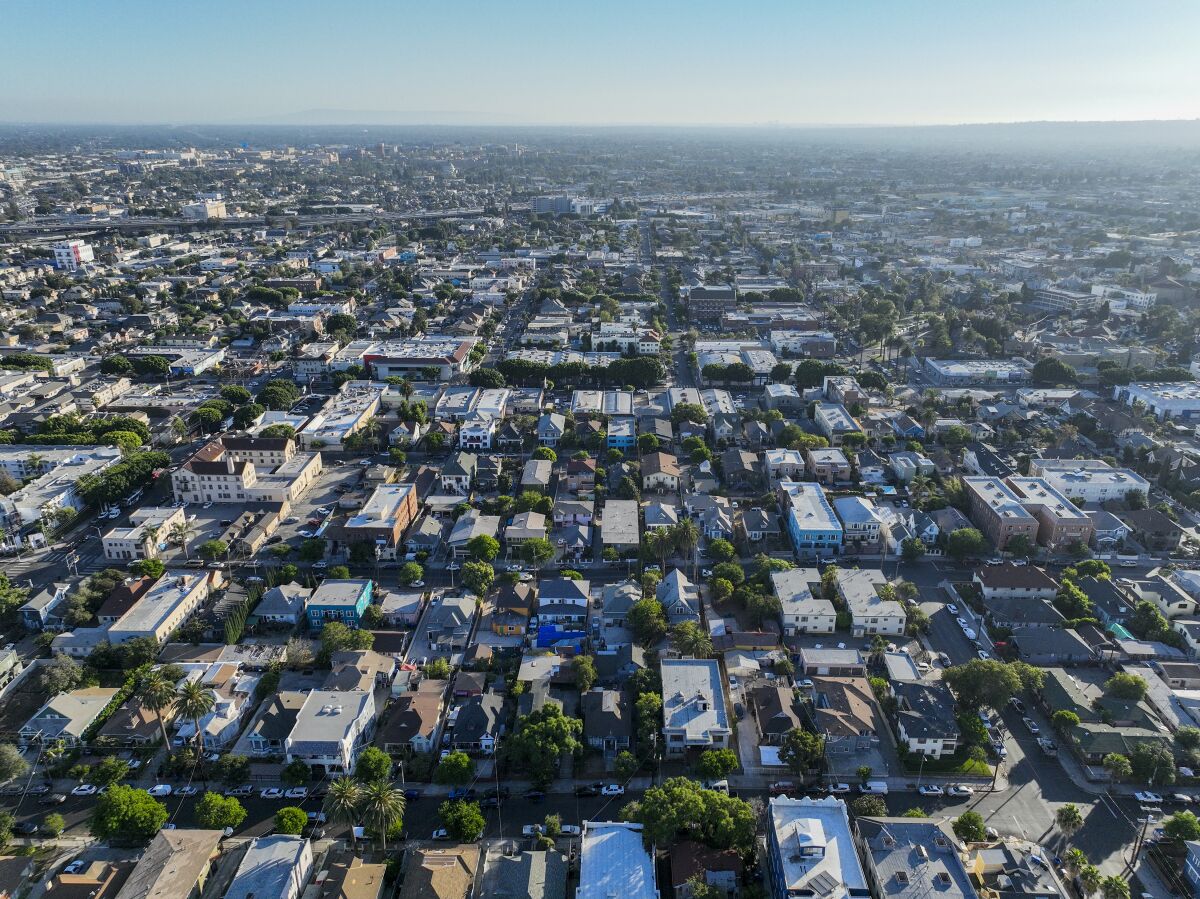 An aerial view of houses and other urban development stretching toward the horizon.