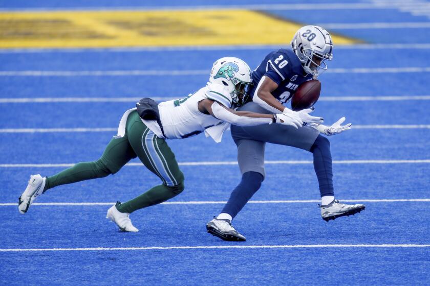 Nevada wide receiver Tory Horton (20) juggles the ball on catching as Tulane defensive back Ajani Kerr (21) moves in for the tackle during the first half of the Idaho Potato Bowl NCAA college football game, Tuesday, Dec. 22, 2020, in Boise, Idaho. (AP Photo/Steve Conner)