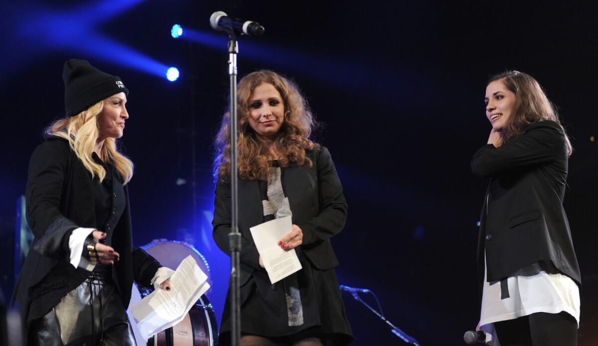 Madonna, left, introduces Maria Alyokhina, center, and Nadezhda Tolokonnikova, formerly of Russian punk protest collective Pussy Riot, at the Amnesty International concert on Feb. 5, 2014, in New York City.