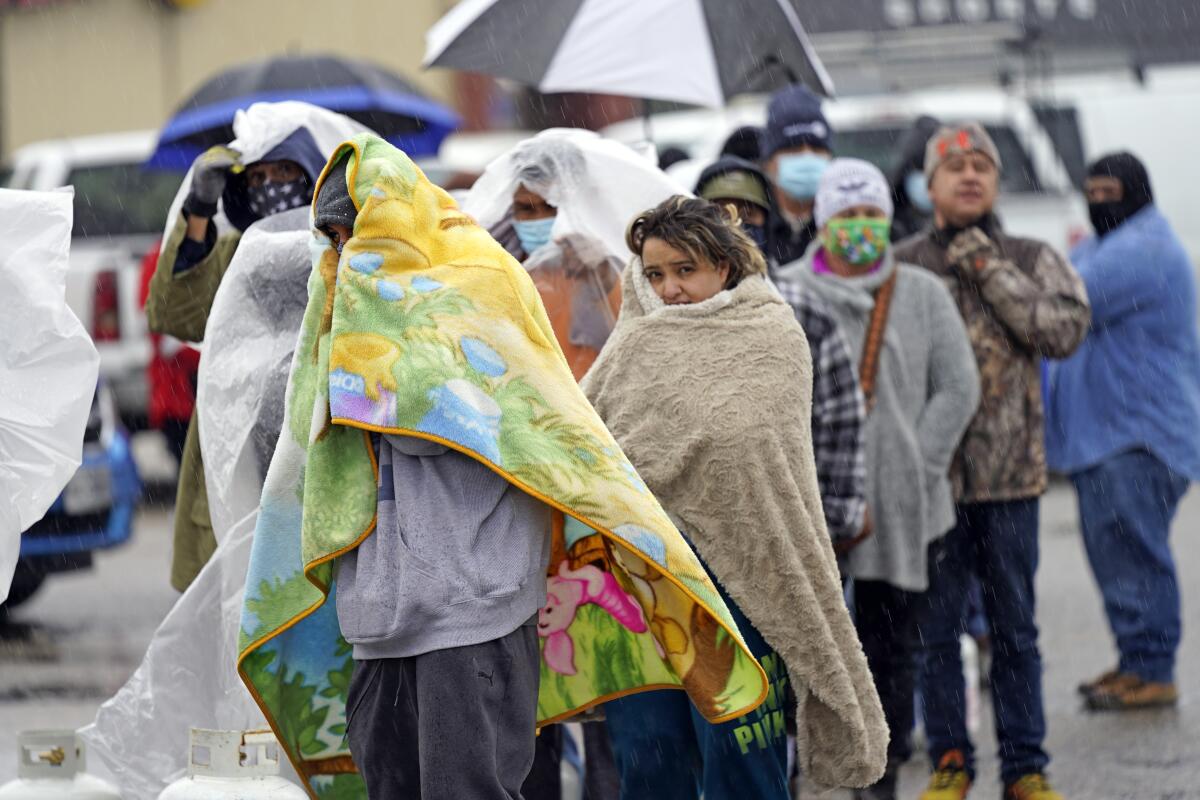 A line of people wrapped in blankets