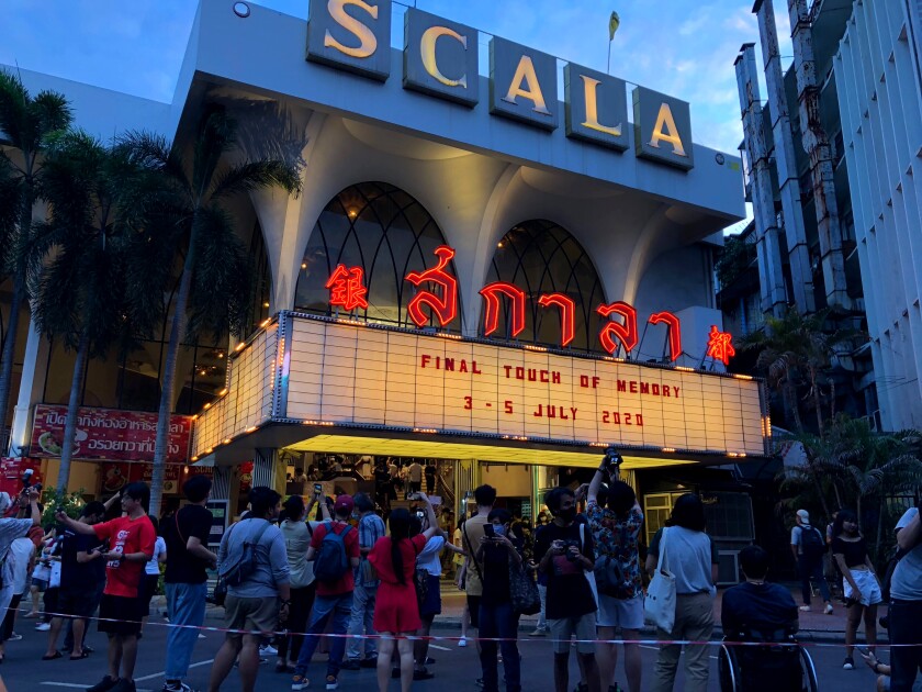 A crowd gathers to take photos of the cinema marquee of the Scala theater during its final movie screening Sunday, July 5, 2020 in Bangkok, Thailand. The Scala theater has shut its doors after 51 years as a shrine for Thai movie-goers. (AP Photo/Jerry Harmer)