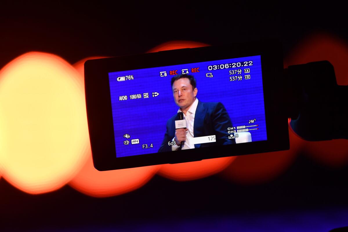 Elon Musk is seen on a screen.