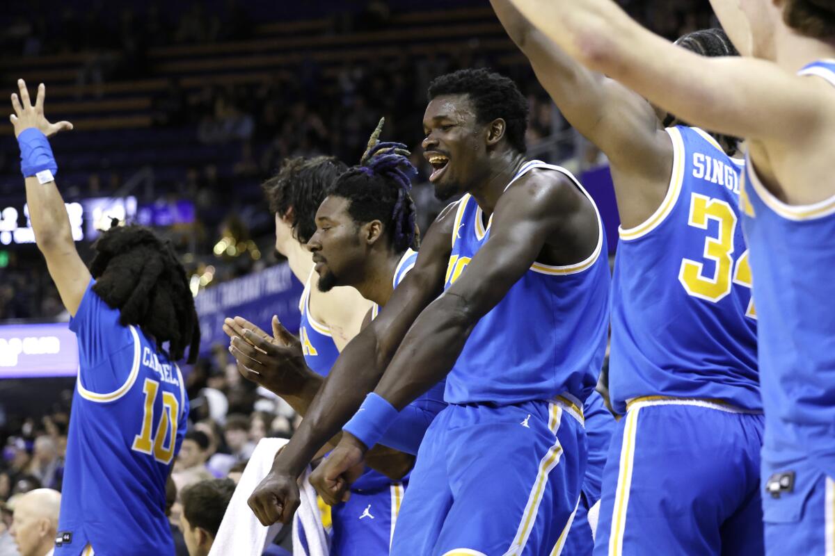 UCLA forward Adem Bona, center with his arms out, celebrates with his teammates.