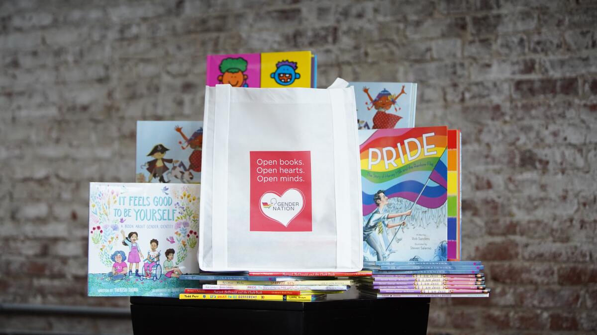 A table display of LGBTQ-affirming children's books with titles including "Pride" and "It Feels Good to Be Yourself"