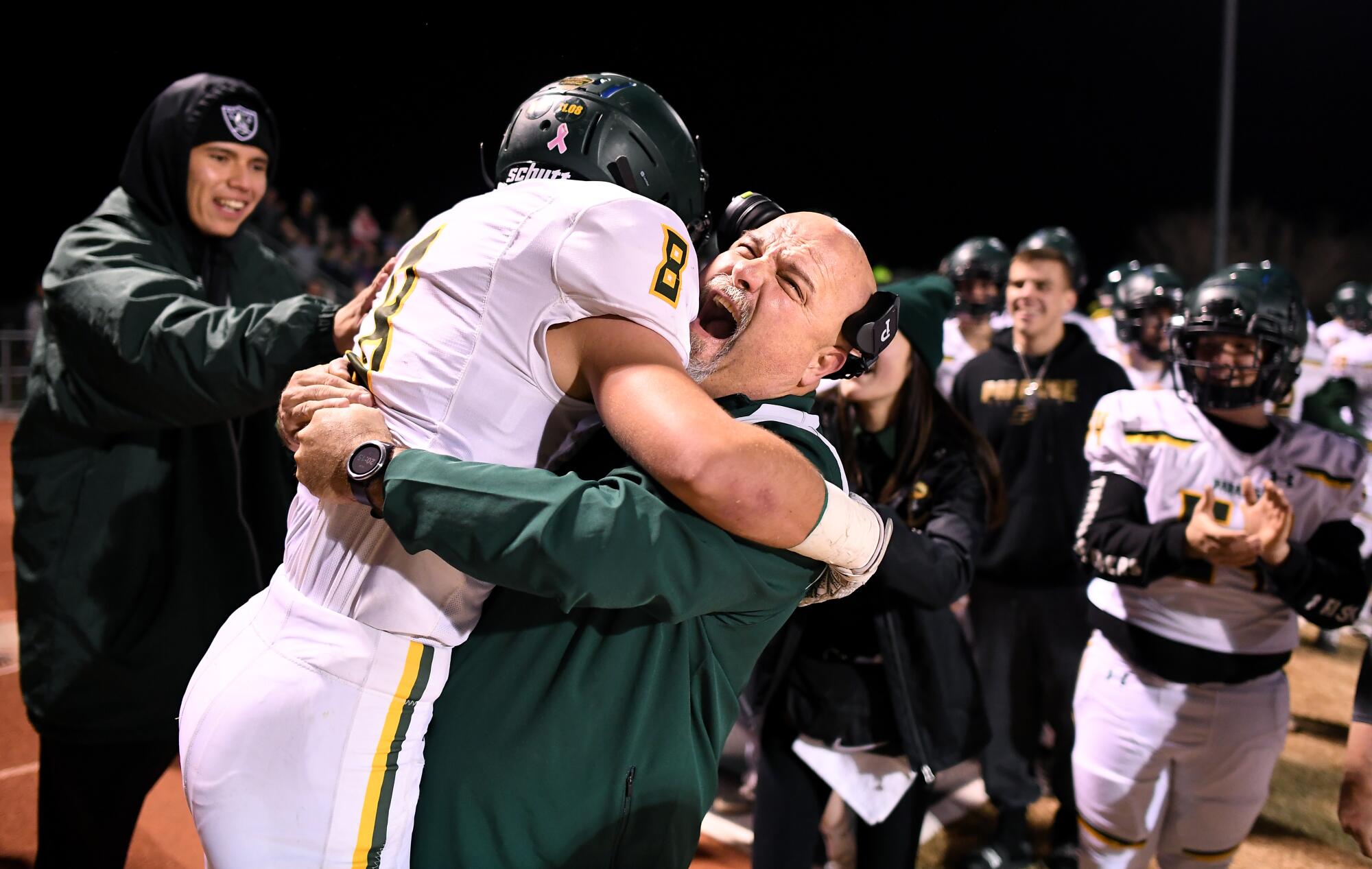 Brenden Moon is hugged on the sideline by assistant coach Nino Pinocchio after his touchdown.