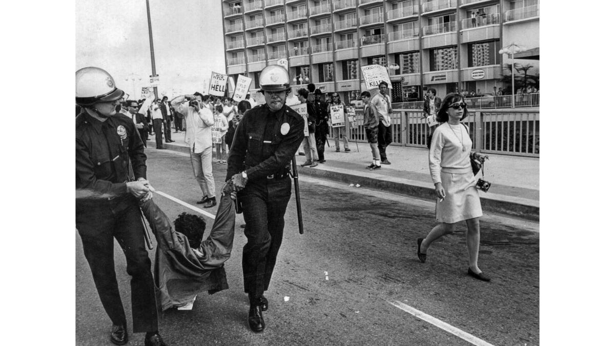 June 23, 1967: An antiwar protester is removed by LAPD officers at Century Plaza Hotel.