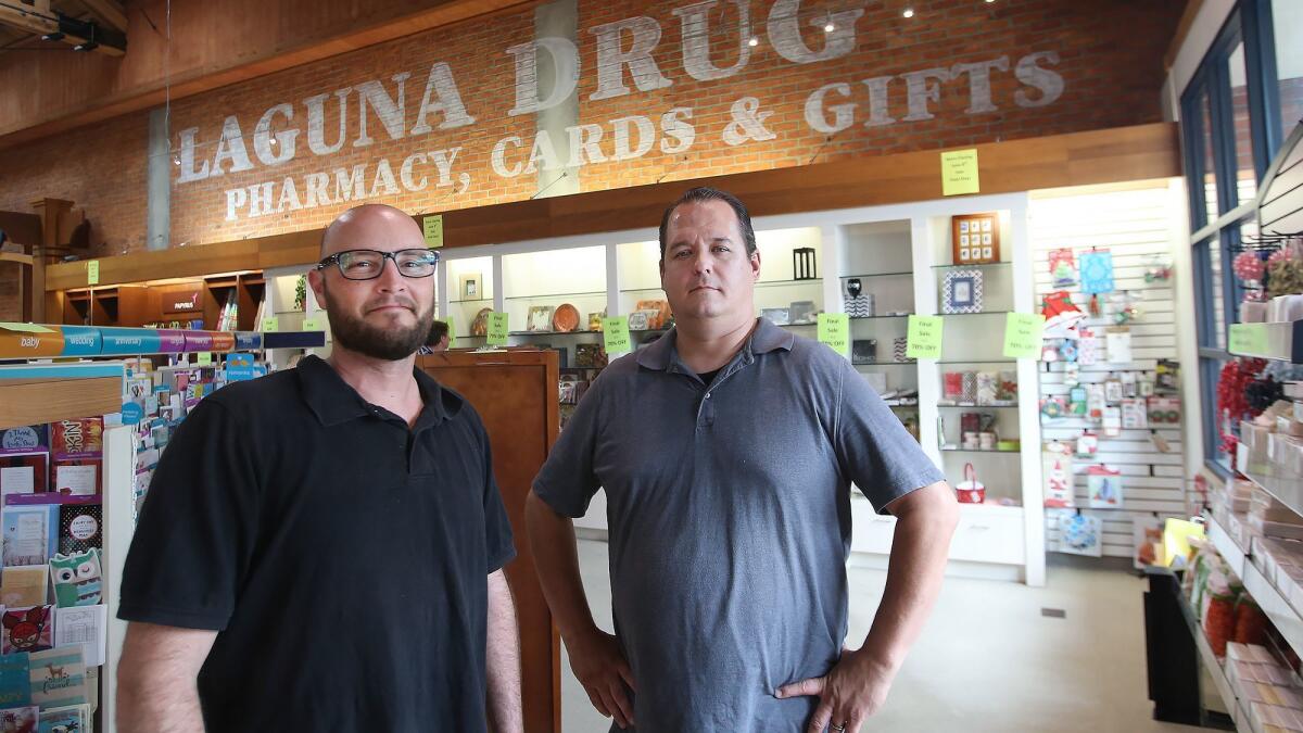 Store managers Mark Bastia, left, and Josh Meili have been overseeing the store’s final weeks. Meili said they have “found jobs for everybody to go somewhere.” Many Laguna Drug employees will move to one of the other two Newport Beach locations.