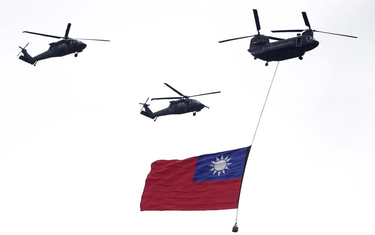 Three helicopters fly and below one flies Taiwanese flag.