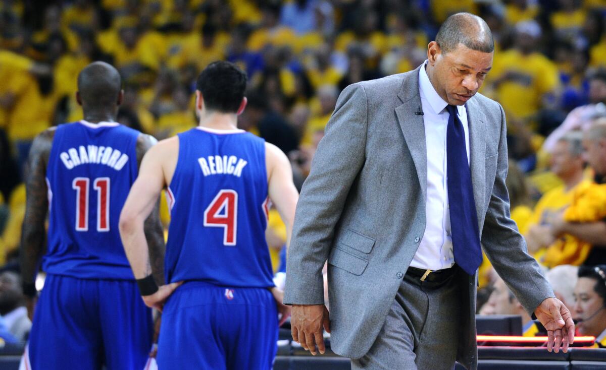 Clippers Coach Doc Rivers heads back to the bench after a timeout during the Clippers' 118-97 loss to the Golden State Warriors in Game 4 of the Western Conference quarterfinals Sunday.
