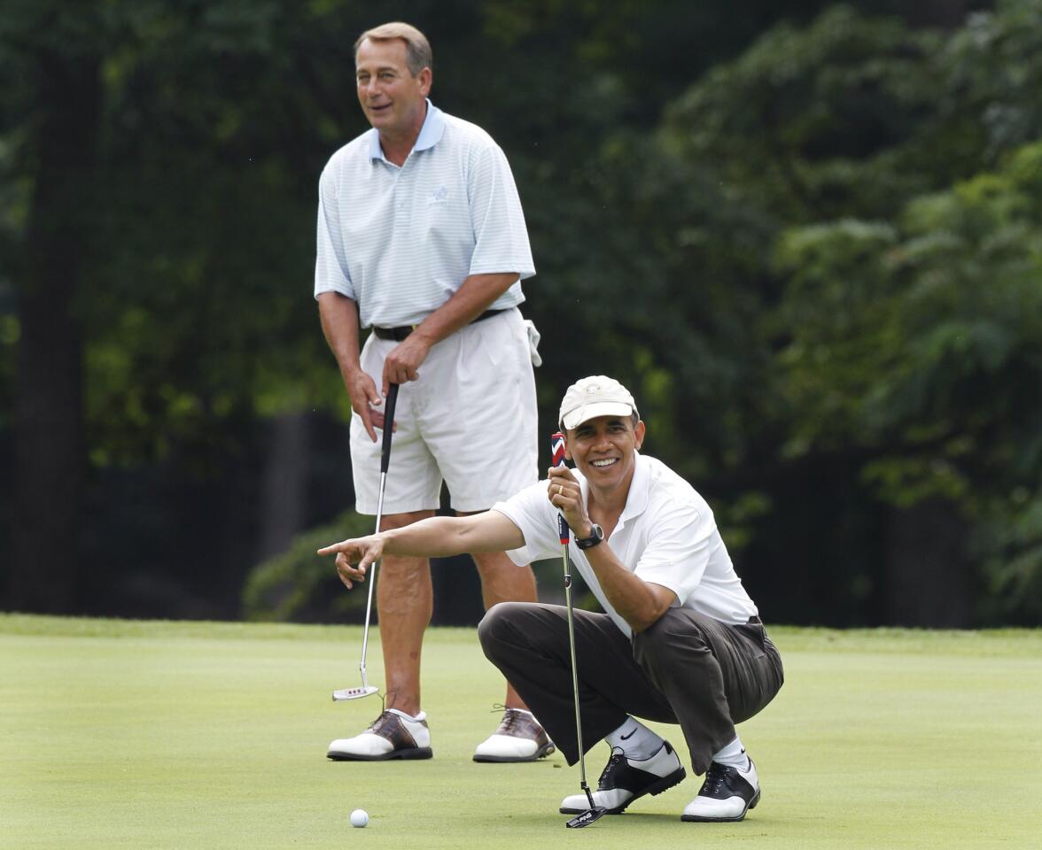 President Obama points to Vice President Joe Biden's putt as he and House Speaker John A. Boehner (R-Ohio) are on the first hole of their golf game at Andrews Air Force Base in Maryland.