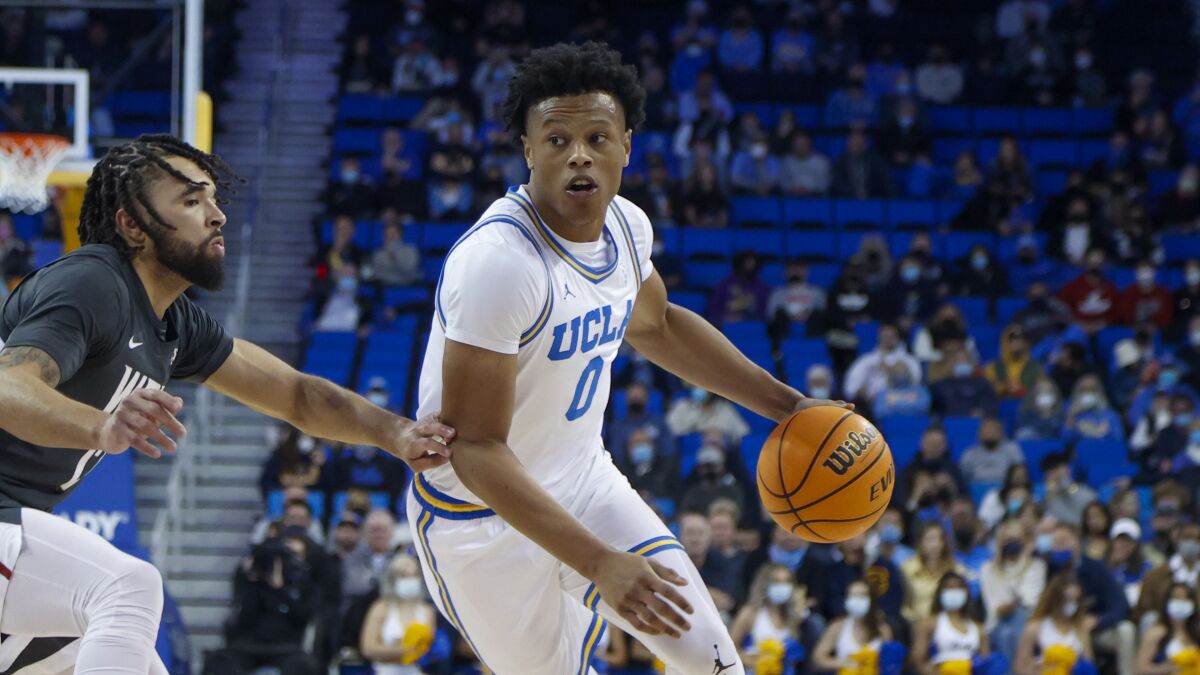 UCLA guard Jaylen Clark drives past Washington State guard Michael Flowers.