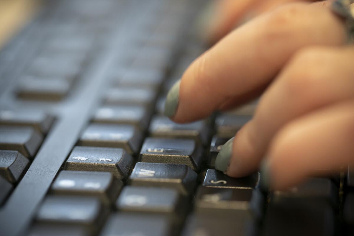 A woman types on a keyboard