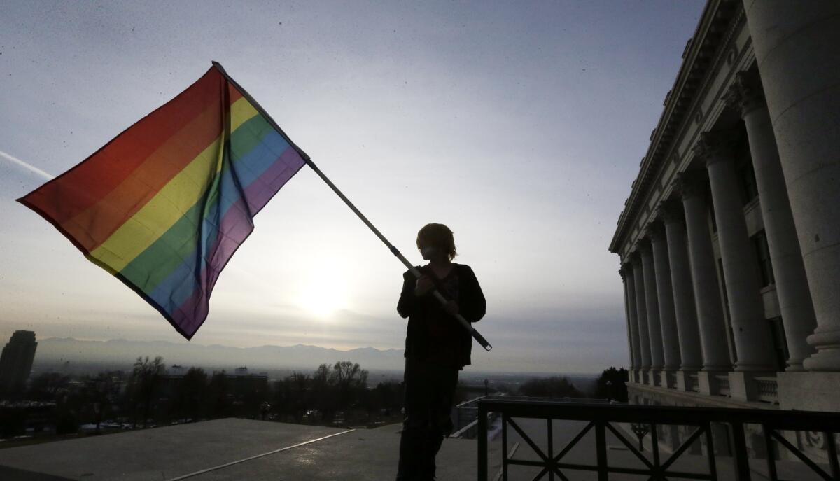 Corbin Aoyagi, a supporter of gay marriage rights, waves a rainbow flag during a rally early this year at the Utah State Capitol in Salt Lake City. The Utah Attorney General's office has petitioned the U.S. Supreme Court to hear its appeal of same-sex marriage.