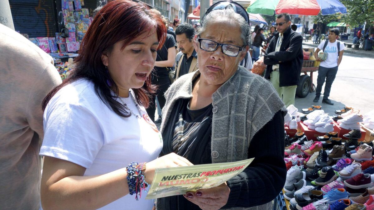FARC congressional candidate Isabela Sanroque, left, talks with street vendor Rosalba Ayala during her walk through of the 20th of July barrio in south Bogota.