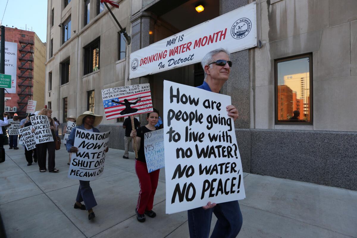Demonstrators protesting water shutoffs rally outside the Detroit Water Department in May.