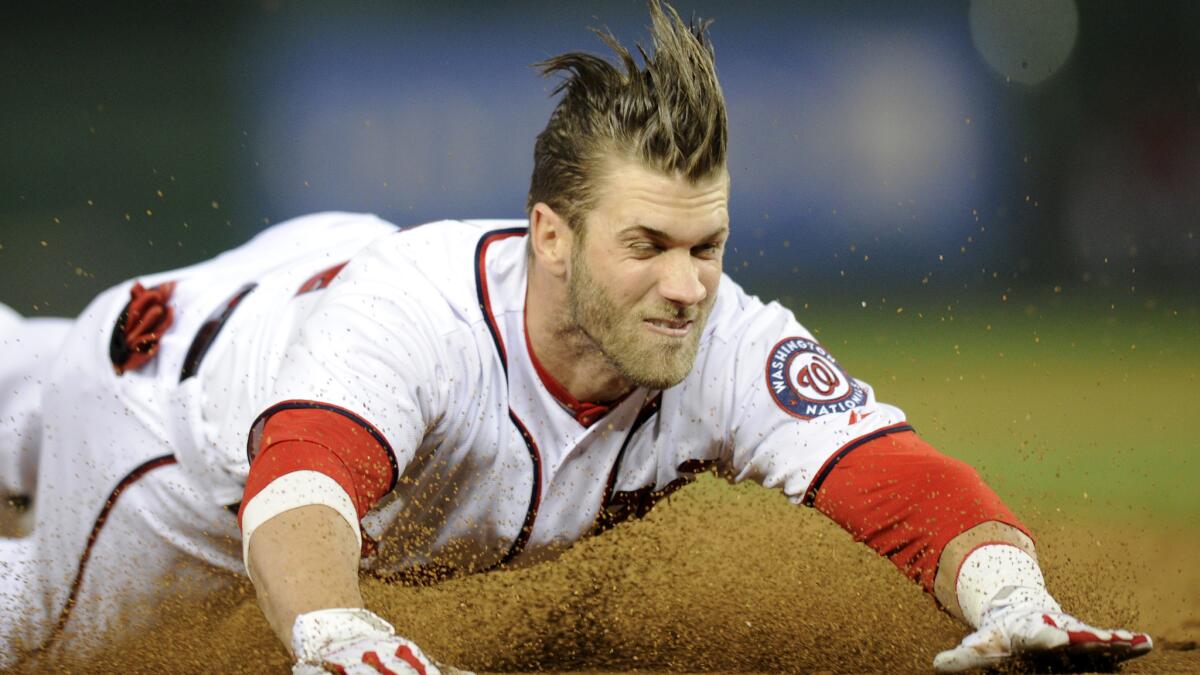 Washington Nationals left fielder Bryce Harper slides into third base on a run-scoring triple during a game against the San Diego Padres on Friday.
