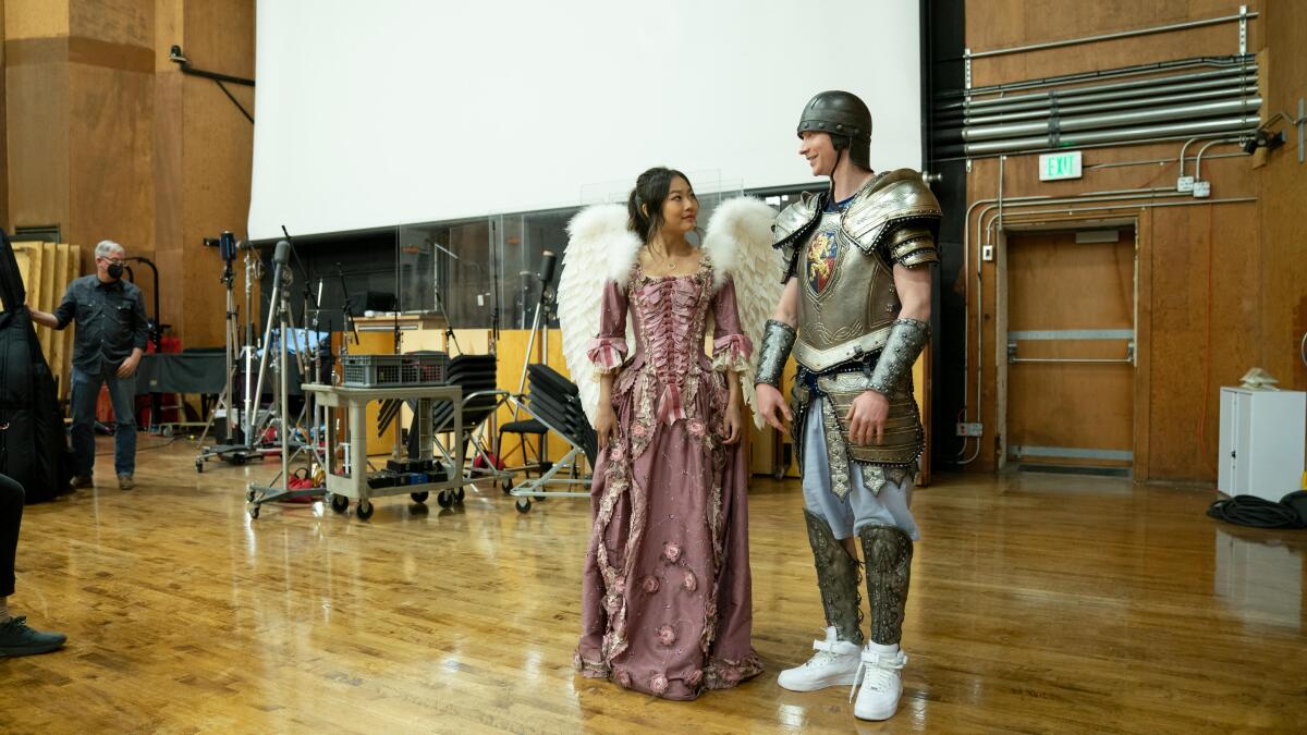 Two young adults in costume on a soundstage