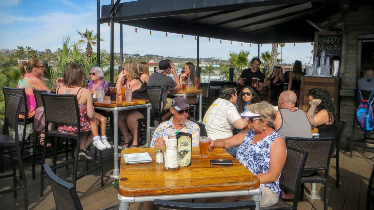 Enjoying food, beer and friends on the upstairs deck at Pacific Beach Alehouse. (Irene Lechowitzky)