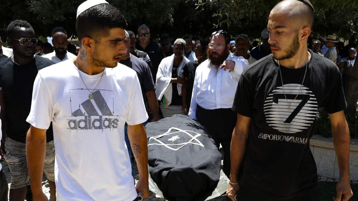 Relatives and friends of Solomon Teka, a young man of Ethiopian descent who was killed by an off-duty Israeli police officer on Sunday, carry his body during his funeral in the Israeli coastal city of Haifa on Tuesday.