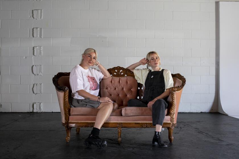 San Diego, California - April 15: Dani Higgins, 43, left, and Laurie Nasica, 32, pose for a portrait inside Department, a space known for throwing art shows and concerts on Friday, April 15, 2022 in San Diego, California. Higgins, owner, opened the space in March of 2020 and wears multiple hats as a DJ, marketing director and director for music videos and Nasica is a painter and sewist. (Ana Ramirez / The San Diego Union-Tribune)