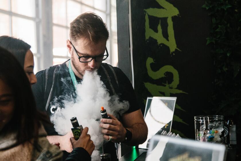 Un hombre expulsa vapor por la boca durante la tercera edición de "Vapevent Trade Show", una feria comercial que recoge las últimas tendencias de vapeo, este jueves en Nueva York (Estados Unidos).