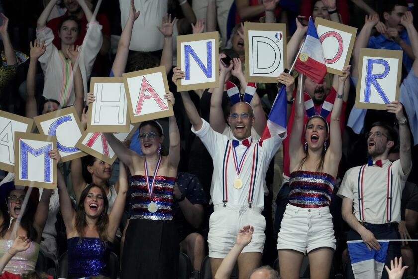 Simpatizantes del nadador francés Léon Marchand previo a su participación en los 400 metros combinados de los Juegos Olímpicos de París, el domingo 28 de julio de 2024, en Nanterre, Francia. (AP Foto/Matthias Schrader)