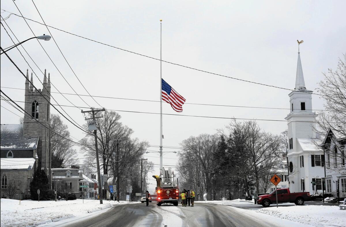 Firefighters in Newtown, Conn., raise the American flag to half-staff last December to mark the first anniversary of the shooting at Sandy Hook Elementary School.