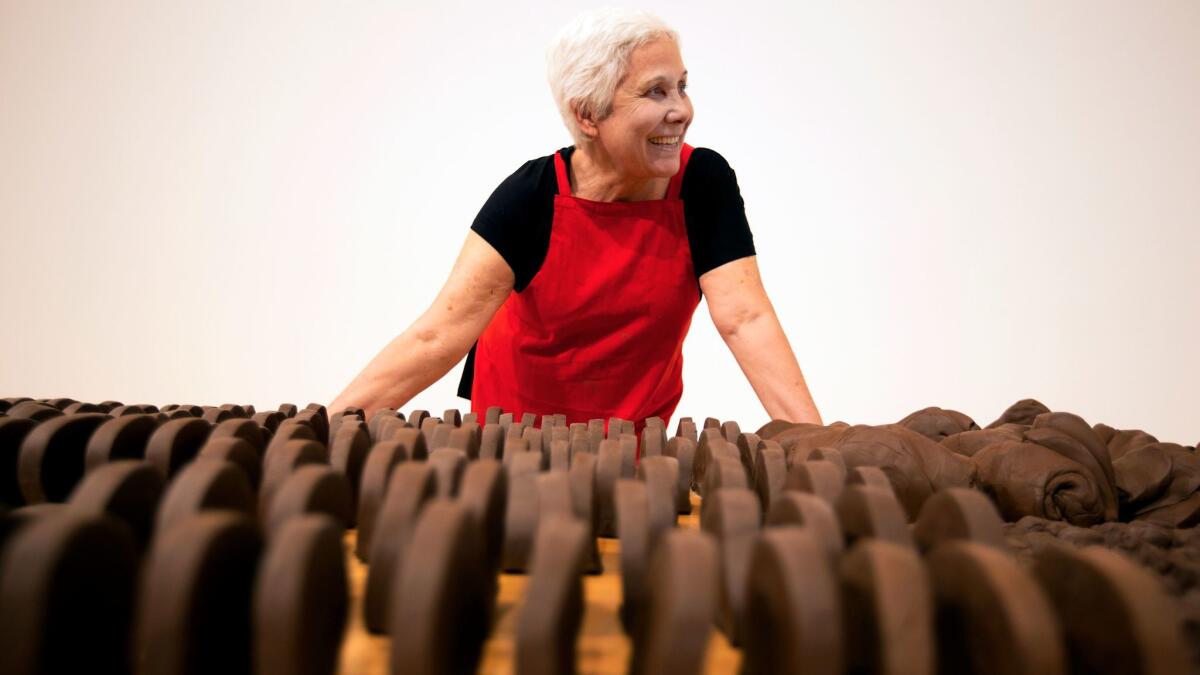 Anna Maria Maiolino stands before unfired clay objects that are part of her MOCA retrospective.